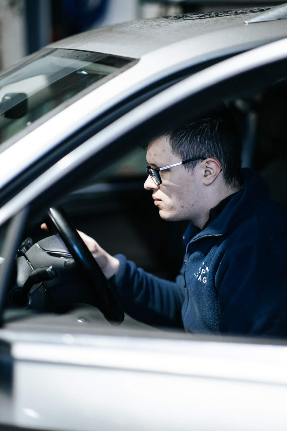 Photo d'un garagiste assis dans une voiture