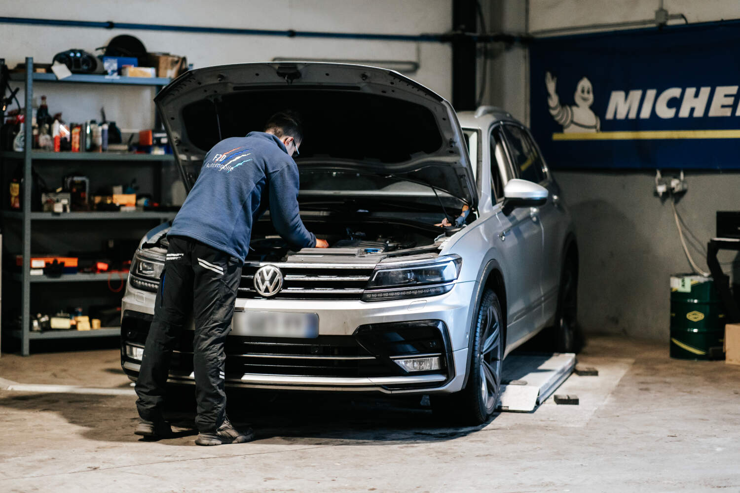 Photo d'un garagiste entrain de réaliser la mécanique sur une voiture