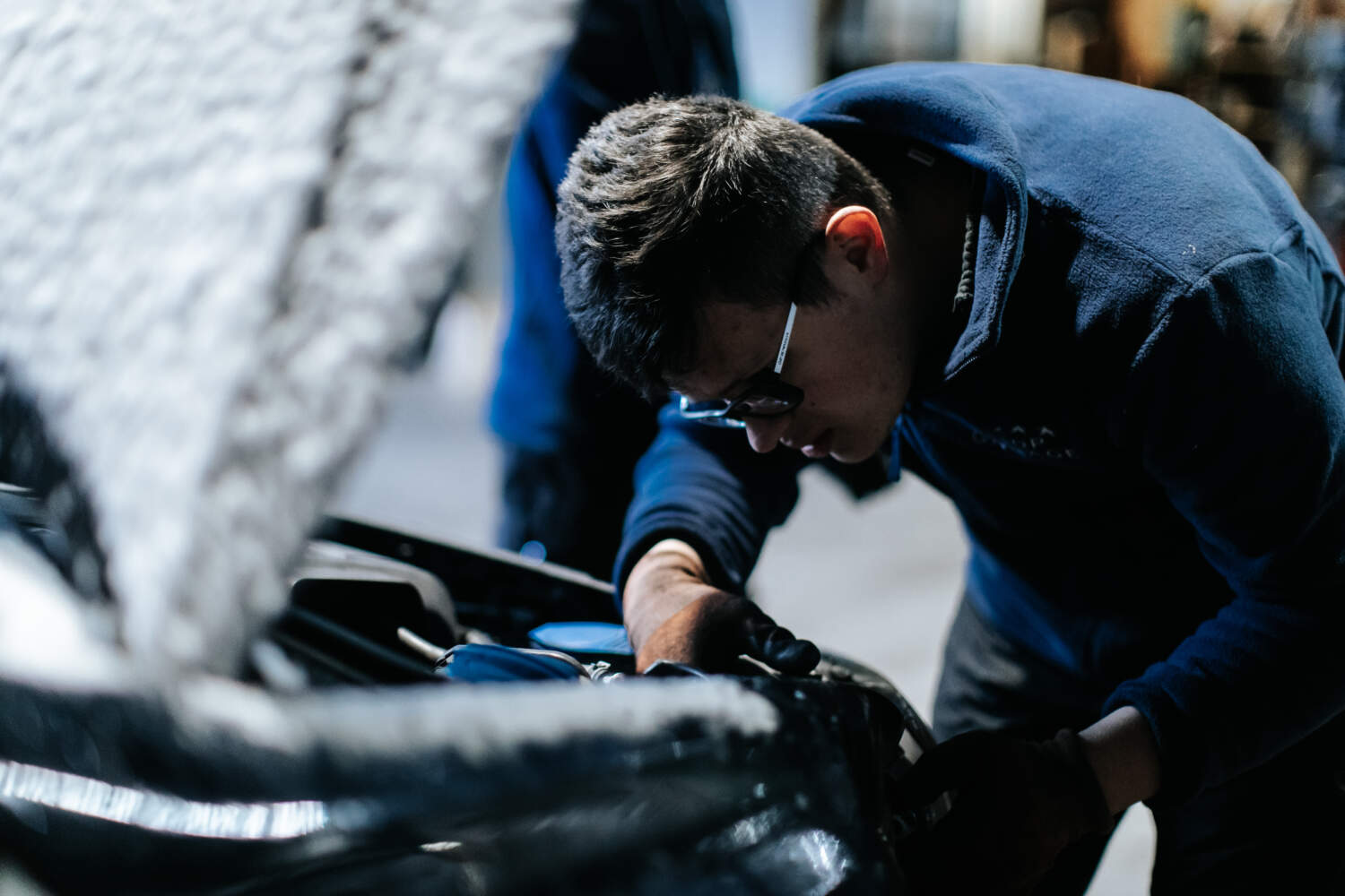 Photo d'un mécanicien entrain de travailler sur une voiture