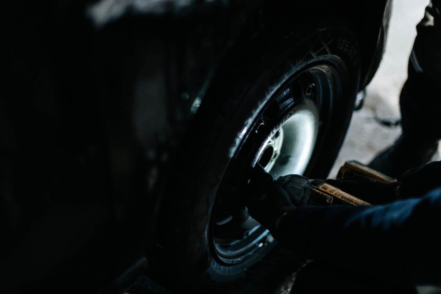 Photo d'un mécanicien entrain de fixer une jante