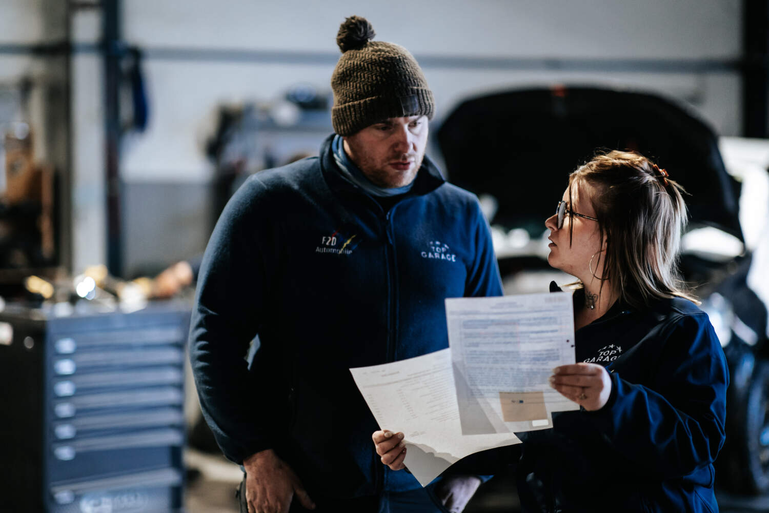 Photo de deux mécaniciens entrain de discuter dans un garage automobile