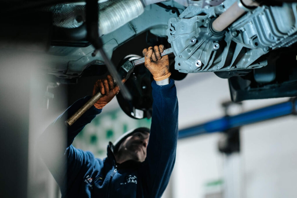 Photo d'un mécanicien entrain de faire un entretien mécanique sur une voiture
